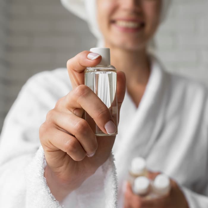 close-up-happy-woman-holding-small-bottle